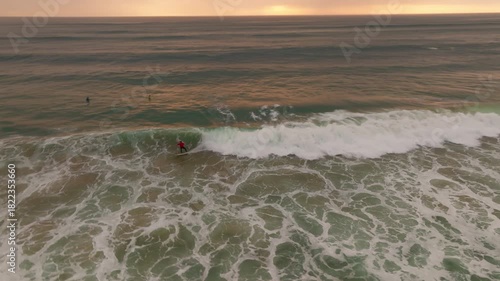 Surfers Riding Waves at Sunset in Portugal