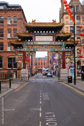 Manchester, uk, January 19th 2025A bustling city street in Chinatown featuring a colorful Chinese arch gate and hundreds of red lanterns. Pedestrians, shops, and vehicles