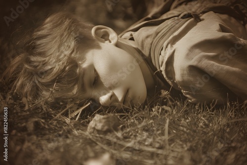 Woman resting peacefully on the grass in sepia tone