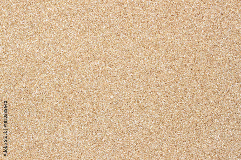 Fototapeta premium Uniform beige granular surface creates soft natural texture resembling fine sand. Concept of texture minimalism, texture pattern, softness form, calm neutral background