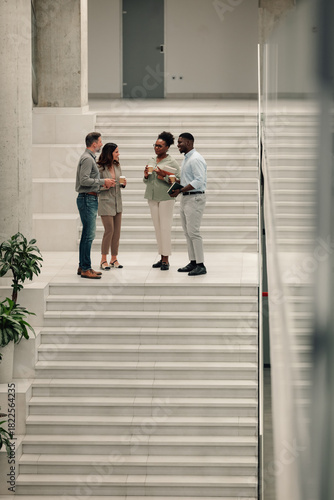 Diverse business people talking on office stairs break