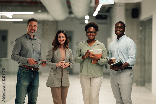 Diverse business team smiling walking in modern office hallway