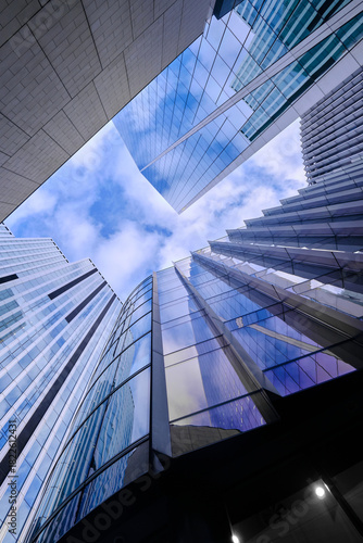 Wide-angle view of skyscrapers in the City of London against a blue sky with light cloud.