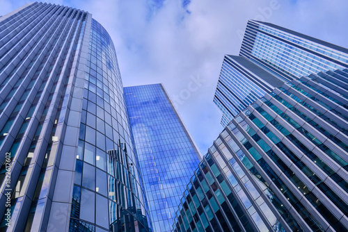 Fototapeta Naklejka Na Ścianę i Meble -  Wide-angle view of skyscrapers in the City of London against a blue sky with light cloud.