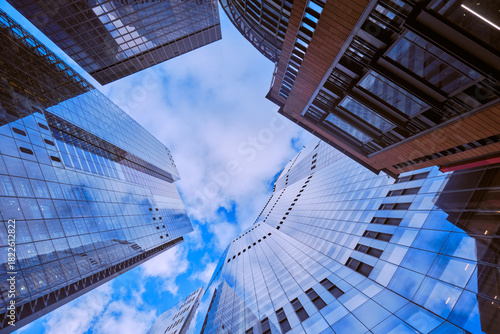Wide-angle view of skyscrapers in the City of London against a blue sky with light cloud.