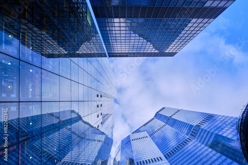 Wide-angle view of skyscrapers in the City of London against a blue sky with light cloud.
