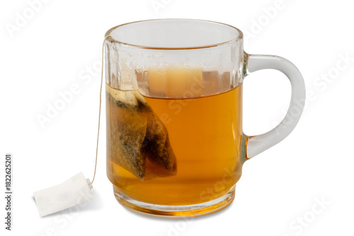 Relaxing digestive herbal tea with chamomile and licorice in a filter bag to be steeped in boiling water in a glass cup isolated