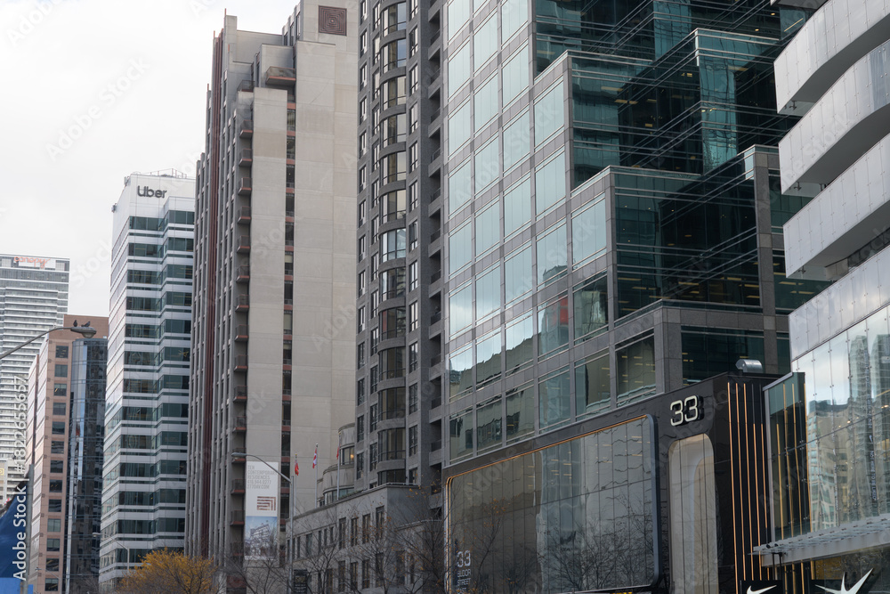 Fototapeta premium looking east on Bloor St E, south side, to towers and shops incl Uber at 121 Bloor E, Toronto