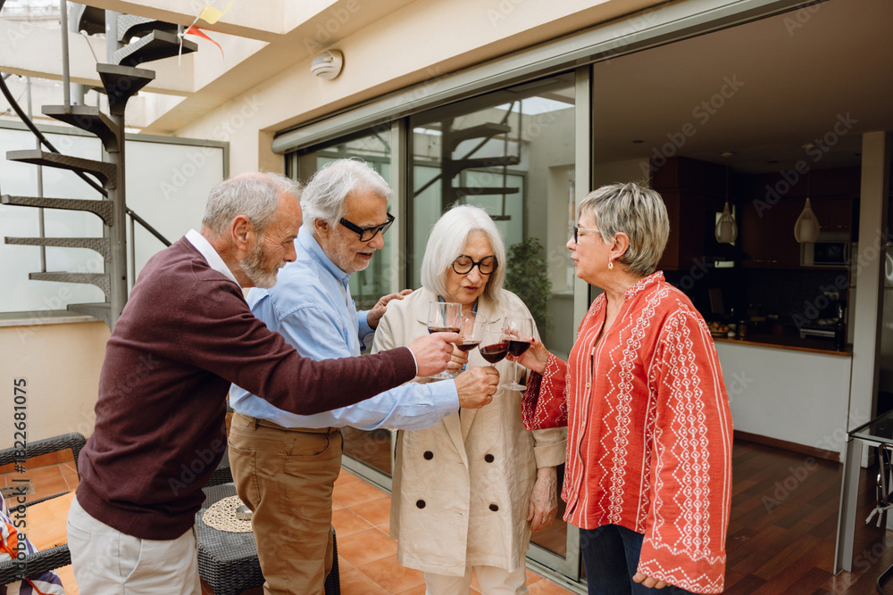 Obraz premium A group of four friends standing and clinking glasses while talking