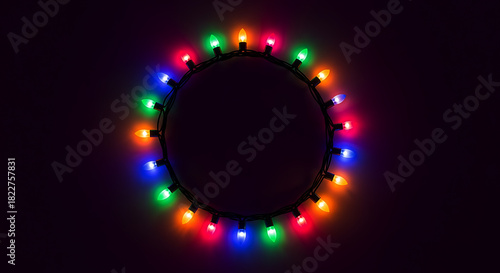 Circle of colorful glowing Christmas lights on dark background string festive