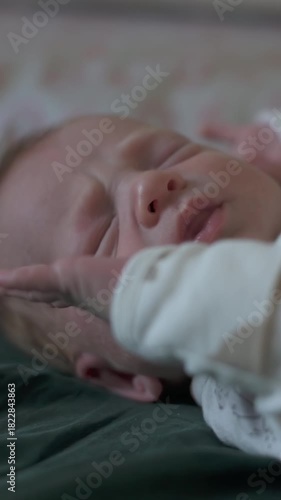 vertical screen infant selfexplores calmly, newborn interacts with environment and demonstrates reflexes, infant carefully examines personal features while engaging with surroundings