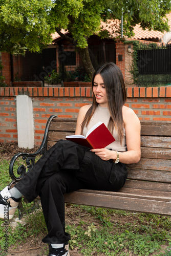 Girl with disgusted expression reading a book at the park