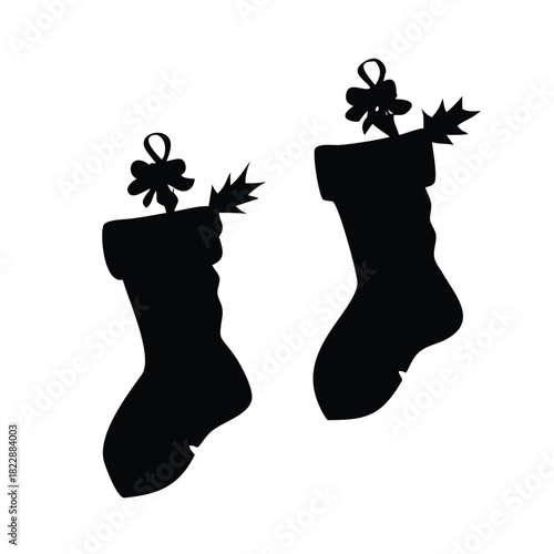 Two black silhouette Christmas stockings hang with festive bows and evergreen sprigs.