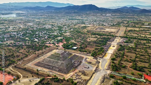 Aerial drone view of the ancient Teotihuacan pyramids with the surrounding Mexican town and mountain landscape