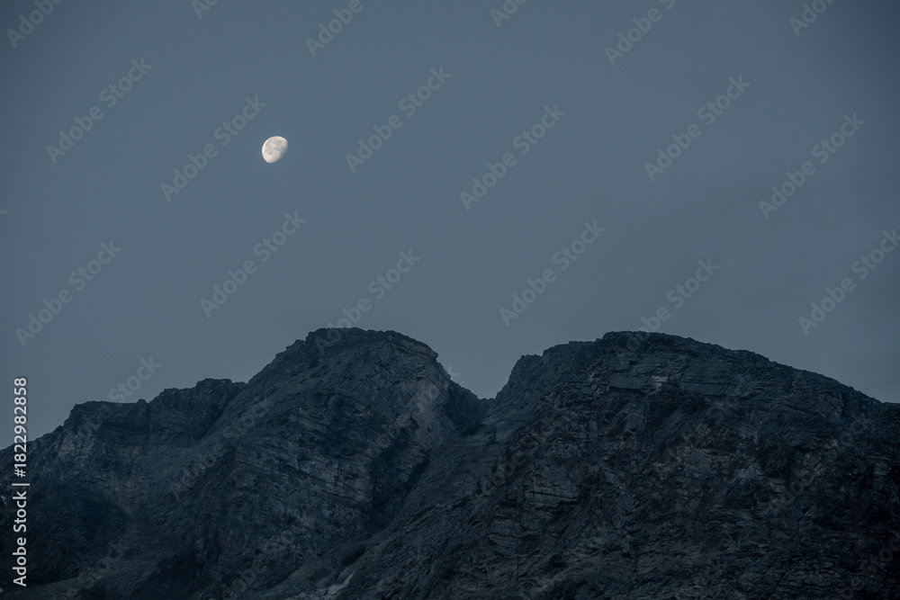Obraz premium Moon Begins To Set Over Rocky Ridge In Glacier