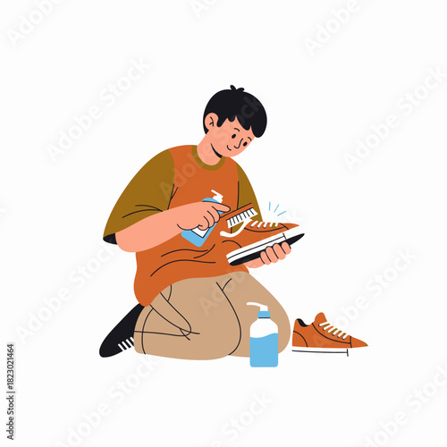 Young man carefully cleaning his sneakers with a brush and spray bottle.
