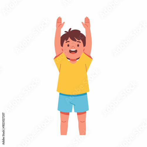 Happy young boy standing with arms raised high in the air.