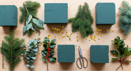 Winter flower arranging workshop setup with greenery, foam blocks, and scissors on wooden table for creating festive bouquets