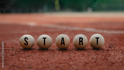 Wooden balls arranged to spell START on a running track, symbolizing new beginnings, motivation, goal setting, and personal growth. Ideal for concepts of inspiration, success, sports mindset, and forw