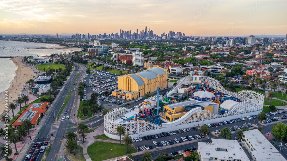 Fototapeta premium Aerial View of St Kilda, Melbourne, Showcasing Luna Park, the Beach, and the Distant City Skyline at Dusk