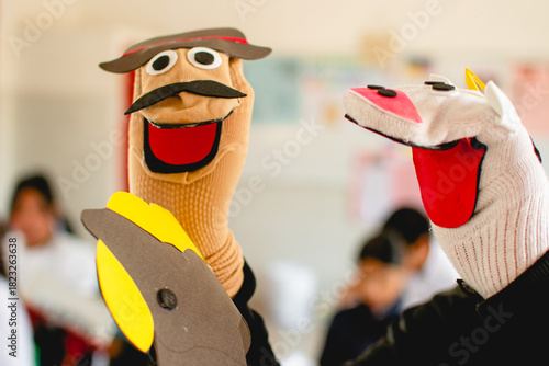Hand puppets performing for children in classroom playing