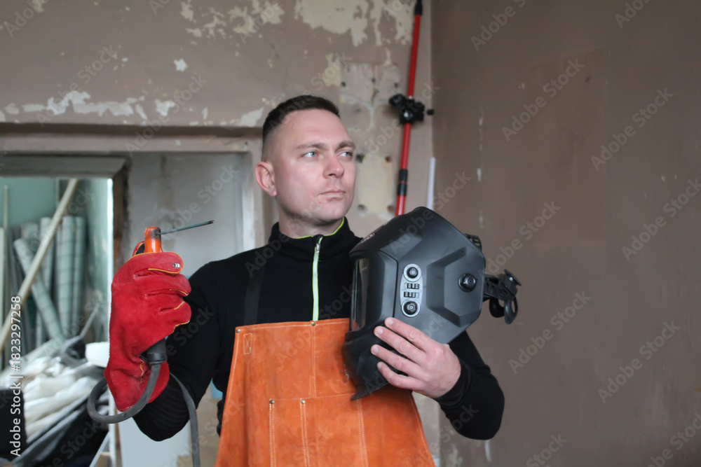 Fototapeta premium Men's chores, men's daily work tasks. A man welder, a man before work with an electrode and clothing.
