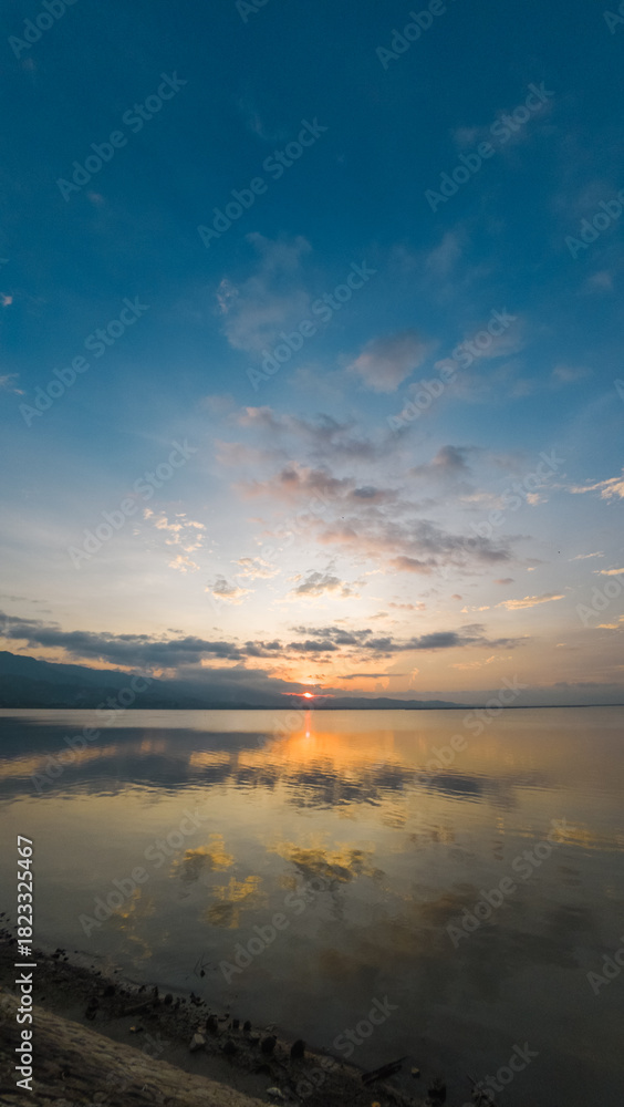Fototapeta premium Scenic Sunrise Reflection Over Calm Water