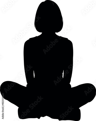Full length silhouette of a woman sitting cross-legged, meditating.