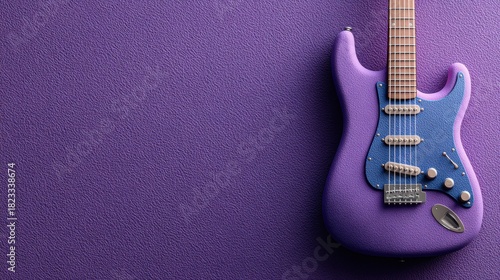 A textured purple electric guitar featuring a blue speckled pickguard rests against a vibrant, glitter covered purple surface, suggesting a musical theme.