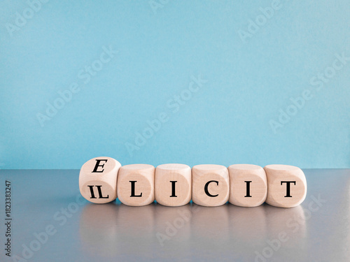 Illicit or elicit symbol. Turned a wooden cube and changes the concept word Illicit to Elicit. Beautiful grey table blue background. Business illicit or elicit concept.