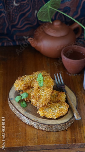 Pisang goreng served on wooden table. Made from fried banana. Selective focus
