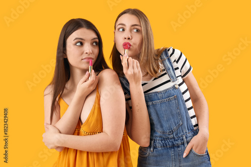 Female friends applying lip...