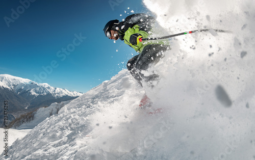 Very fast professional skier or instructor rides in cloud of powder snow outside of organized ski slope. Backcountry or freeride at ski resort concept
