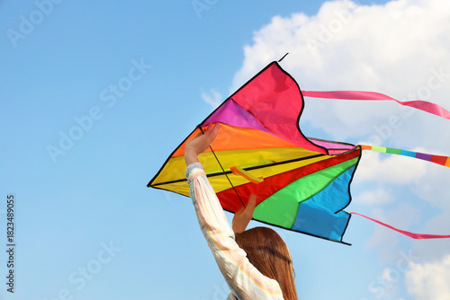 Young woman flying kite in ...