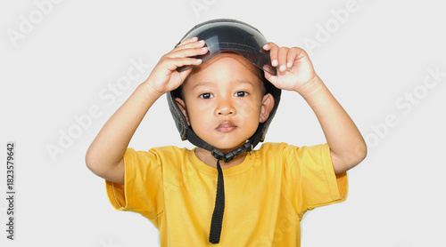 A 3 year old Asian boy wearing a small brown helmet when his parents take him on a motorbike, to be safe when riding on the highway, obeying the rules, role models, isolated on a white background