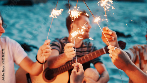 Billede på lærred People, hands and night with sparklers on beach for new year, outdoor event or social gathering