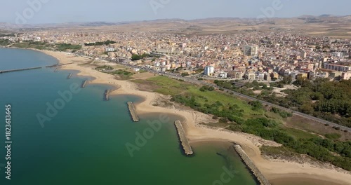 Aerial view of the waterfront of the city of Gela, located in the province of Caltanissetta, Sicily, Italy. It is a small town overlooking the Mediterranean Sea. It has a long sandy beach.
