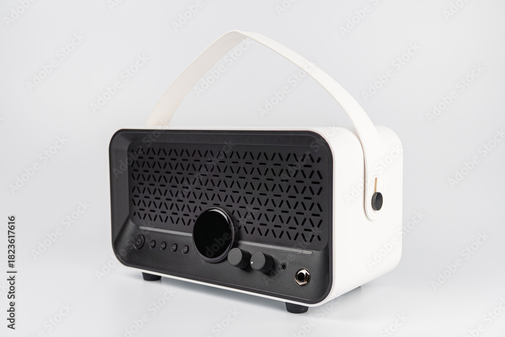Fototapeta premium Modern, white, portable mini guitar amplifier speaker with patterned grill, central dial knob, two buttons larger and smaller, four raised feet, clean background