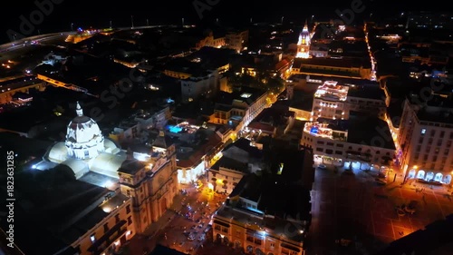 Aerial drone view of Cartagena's illuminated cathedral and surrounding colonial buildings at night