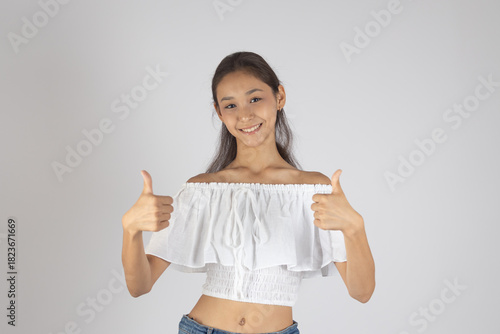 A woman is smiling and giving two thumbs up