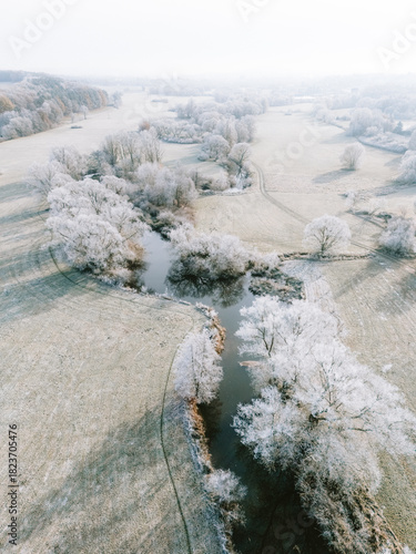 Luftaufnahmen einer winterlichen Flussauen-Landschaft bei Sonnenschein