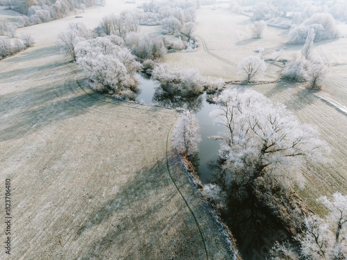 Luftaufnahmen einer winterlichen Flussauen-Landschaft bei Sonnenschein