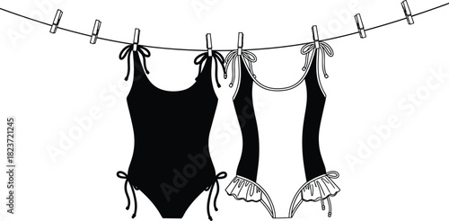 Black and white one piece swimsuits hanging on a clothesline with clothespins swimwear