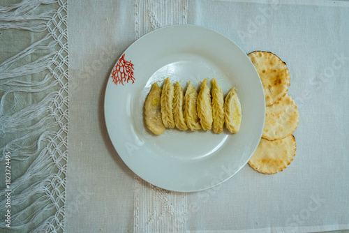 Homemade traditional Sardinian pasta called Culurgiones on a porcelain plate
