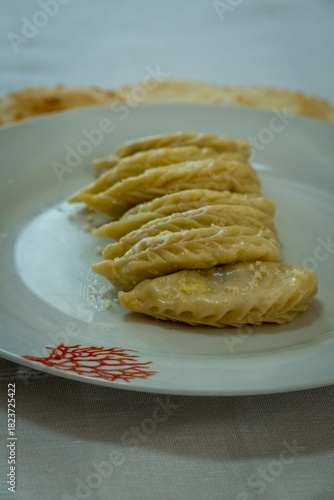 Homemade traditional Sardinian pasta called Culurgiones on a porcelain plate