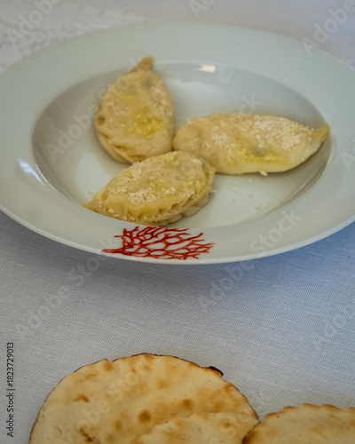 Homemade traditional Sardinian pasta called Culurgiones on a porcelain plate