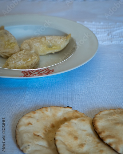 Homemade traditional Sardinian pasta called Culurgiones on a porcelain plate