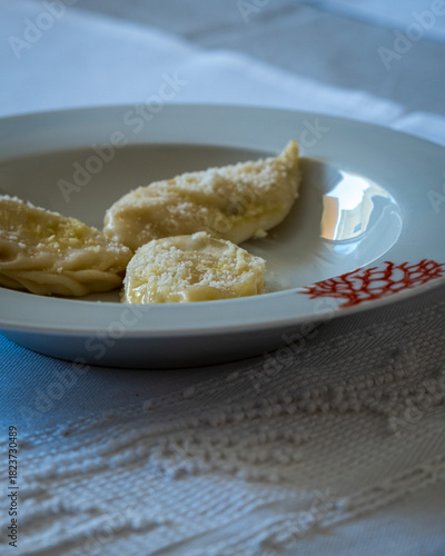 Homemade traditional Sardinian pasta called Culurgiones on a porcelain plate
