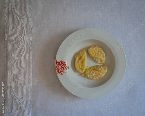 Homemade traditional Sardinian pasta called Culurgiones on a porcelain plate