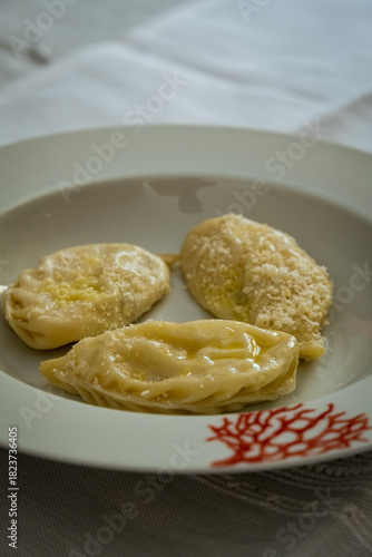 Homemade traditional Sardinian pasta called Culurgiones on a porcelain plate